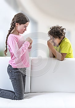 Happy preschool children brother sister having fun together playing at home,, Two Children Making Faces on the sofa