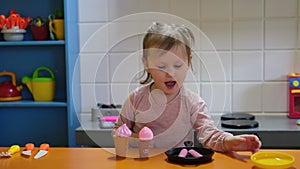 Happy preschool girl playing with toy kitchen at kids game center. Fun in kids room.