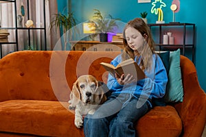 Happy preteen girl reading book turning pages smiling enjoying literature education