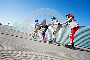 Happy preteen kids having fun while rollerblading