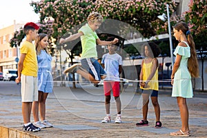 Happy preteen kids skipping on chinese jump rope