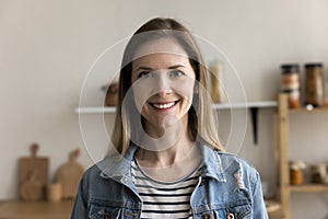 Happy pretty 30s Caucasian woman posing in home kitchen