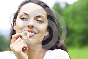 Happy pretty brunette woman in chamomile field