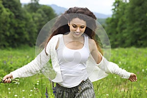 Happy pretty brunette woman in chamomile field, cute female relaxed on flowers meadow photo