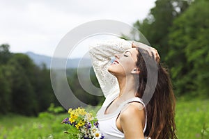 Happy pretty brunette woman in chamomile field photo