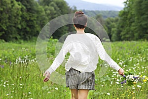 Happy pretty brunette woman in chamomile field photo