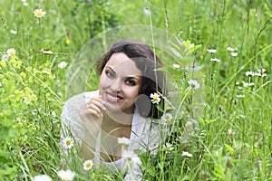 Happy pretty brunette woman in chamomile field photo