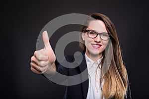 Happy pretty business woman holding thumb up