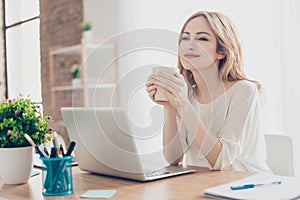 Happy pretty cute woman working with computer enjoying coffee