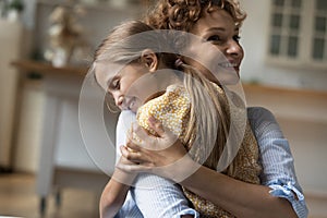 Happy pretty little preschool 6s kid girl cuddling loving mother.