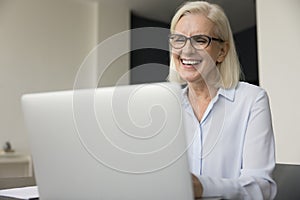 Happy pretty mature older business woman in elegant eye glasses