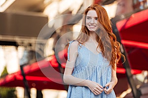 Happy pretty redhead girl with long hair posing