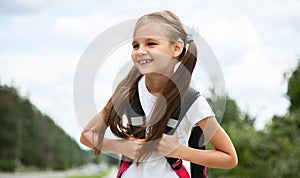 Happy pretty school girl holding backpack. schooler going to school, enjoying studying. School, education concept