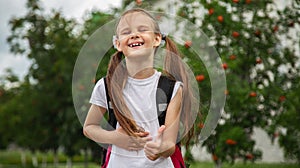 Happy pretty school girl holding backpack. schooler going to school, enjoying studying. School, education concept