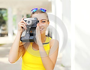 Happy pretty smiling young woman with retro vintage camera