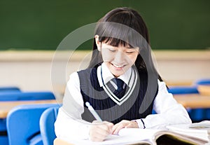 Happy pretty student girl with books in classroom