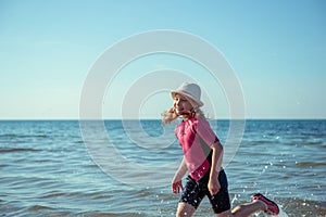 Happy pretty teen girl in neoprene swimingsuit  running in Baltic sea