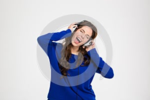 Happy pretty woman in headphones listening to music and singing