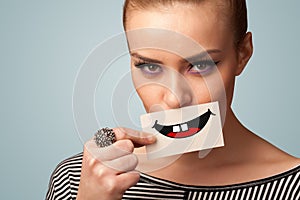 Happy pretty woman holding card with funny smiley