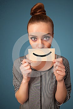 Happy pretty woman holding card with funny smiley