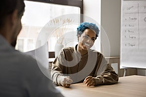 Happy pretty young African candidate laughing at successful job interview