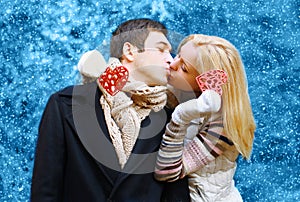 Happy pretty young couple in love kissing in winter