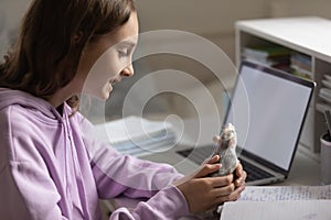 Happy pretty young teenager playing with domesticated rat.