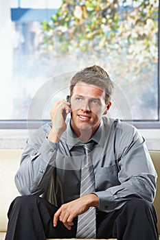 Happy professional getting news on phone