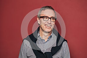 Happy professional mature man on red background portrait