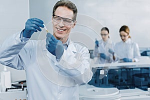 Happy professional scientist holding a test tube