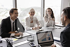 Happy professional team members negotiate in modern office photo