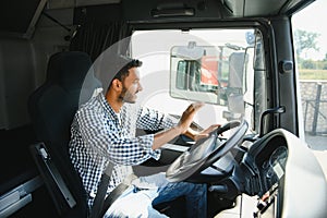 Happy professional truck driver driving his truck. Copy space.