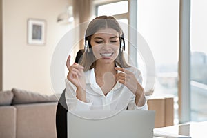 Happy professional woman in wireless earphones talking on video call