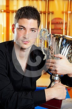 Happy proud winner man with big trophy silver cup
