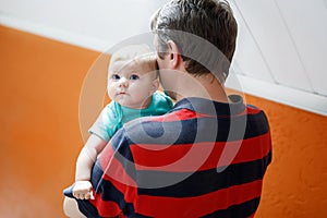 Happy proud young father having fun with newborn baby daughter, family portrait togehter. Dad with baby girl, love