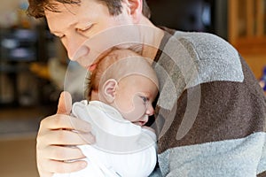 Happy proud young father having fun with newborn baby daughter, family portrait togehter. Dad with baby girl, love. New