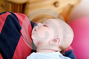 Happy proud young father holding little sleeping baby daughter, family portrait together.