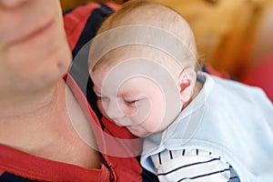 Happy proud young father holding little sleeping baby daughter, family portrait together.