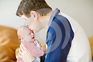 Happy proud young father with newborn baby daughter, family portrait togehter