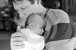 Happy proud young father with newborn baby daughter, family portrait togehter