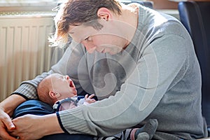 Happy proud young father with newborn baby daughter, family portrait togehter