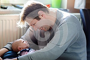Happy proud young father with newborn baby daughter, family portrait togehter