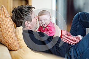 Happy proud young father with newborn baby daughter, family portrait together