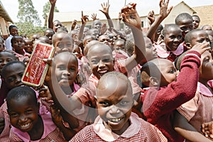 Happy African students getting school material Schoolgirls and Schoolboys in Uganda with new school material.
