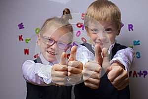 Happy pupils showing thumbs up. Back to school concept.