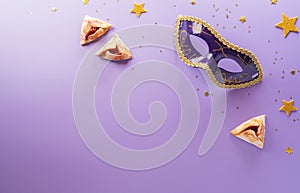 Happy Purim carnival decoration concept made from mask and sparkle star and hamantaschen cookies on pastel background. Happy