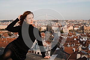 Happy readhead woman start fresh new life looking at Prague centre and Charles Bridge view from above
