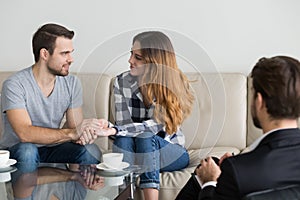 Happy reconciled couple holding hands satisfied with family therapy session