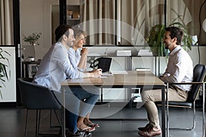 Happy recruiters talk with male applicant in office