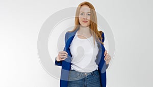 Happy red haired business woman in template blank white t shirt and stylish jacket isolated on gray background. Self career